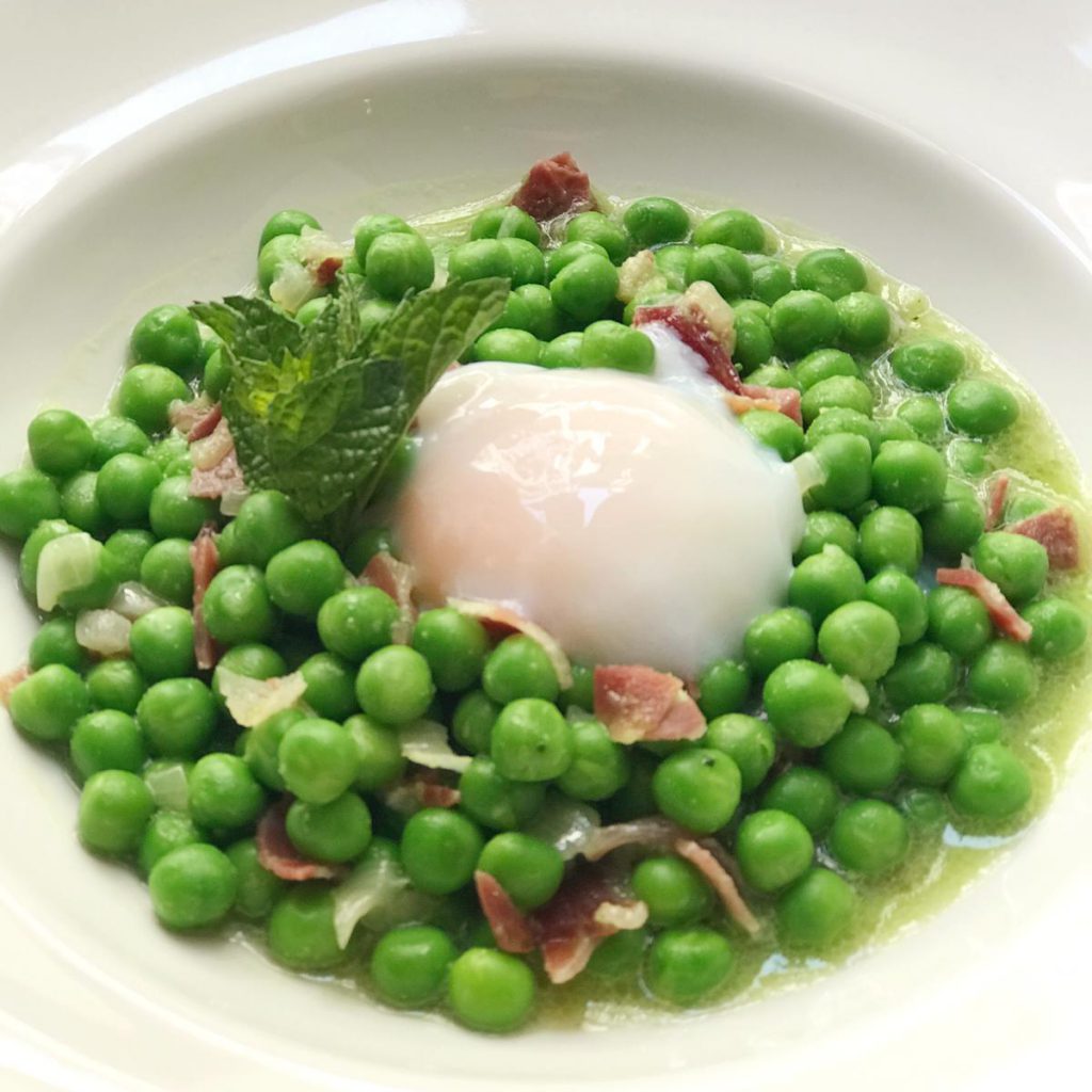 Guisantes salteados con ajo y jamón y huevo poché